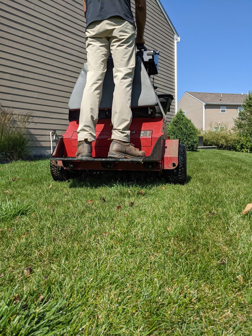 A West Metro Lawn & Snow core aerator pulling plugs on a west metro lawn