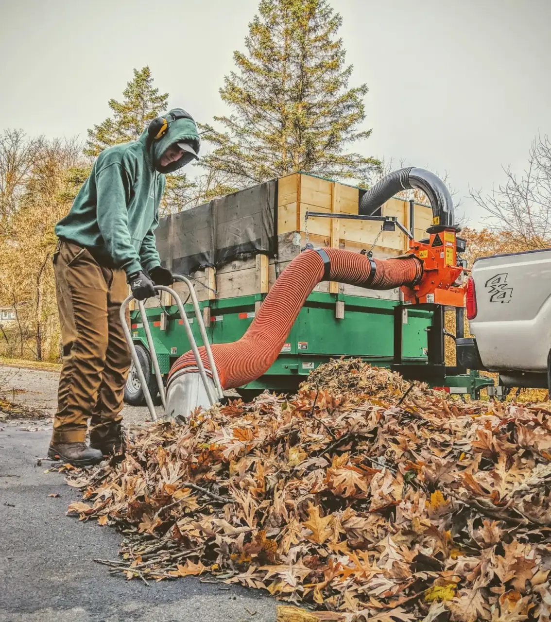 West Metro crew vacuuming fall leaves with truck-mounted leaf loader